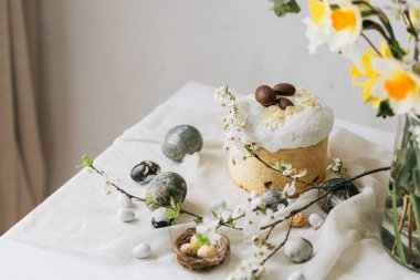 Paskalya yumurtaları, panettone, bahar çiçekleri ve çarşaf örtüsü üzerinde çikolata yumurtaları. Doğal boya mermer yumurtalar ve kiraz çiçekleri, asgari yaşam. Mutlu Paskalyalar!