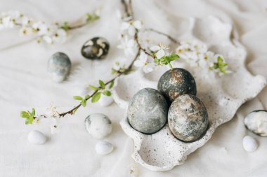 Paskalya yumurtaları ve kır masasında bahar çiçekleri. Mutlu Paskalyalar! Doğal boya mermer yumurtalar tepside ve kiraz çiçeklerinde. Mutlu Paskalyalar! Tatil için en az yaşam süresi