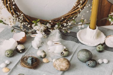 Mutlu Paskalyalar! Paskalya yumurtaları, tavşanlar ve kiraz çiçekleri köy masasında. Modern doğal boyanmış mermer yumurta ve bahar çiçekleri. Paskalya 'da kırsal evdeki hayat dekorasyonu