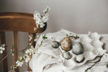 Mutlu Paskalyalar! Paskalya yumurtaları tepside ve kiraz çiçekleri kırsal masada. Modern doğal boya mermer yumurtalar ve bahar çiçekleri natürmort. Kırsal Paskalya Kompozisyonu