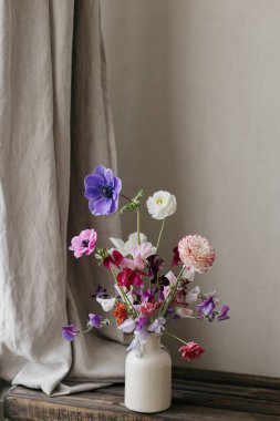 Kırsal ahşap bankta şık bir buket. Güzel renkli şakayık, ranunculus, vazoda latilus. Yaz çiçekleri, çiçekli natürmortlar. Anneler Günün kutlu olsun, metin için yer