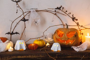 Mutlu Cadılar Bayramı! Korkunç balkabağı, parlayan hayaletler, masada örümcekler ve yarasalar. Cadılar Bayramı dekoru, ürkütücü Jack o fener ve mumlarla dolu, mesaj için yer var. Şaka mı şeker mi?