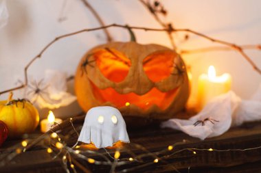 Mutlu Cadılar Bayramı! Şirin parlayan hayalet, korkunç balkabağı, masada örümcekler ve yarasalar. Cadılar Bayramı dekoru, ürkütücü Jack o fener ve ışıklar, mesaj için yer. Şaka mı şeker mi?