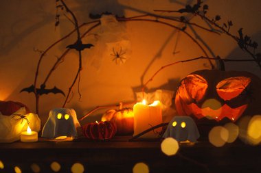 Mutlu Cadılar Bayramı! Korkunç Jack o fener kabağı, parlayan hayaletler, ışıklar, örümcekler ve karanlıkta yarasalar. Atmosferik cadılar bayramı dekoru, şenlikli sonbahar natürmortu. Şaka mı şeker mi?