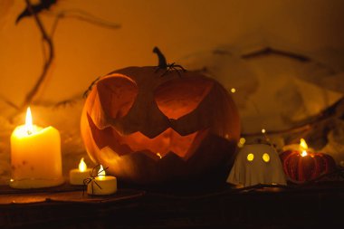 Korkunç Jack o fener kabağı, parlayan hayaletler, akşamları örümcekler ve yarasalar. Mutlu Cadılar Bayramı! Masada atmosferik cadılar bayramı dekorasyonu, metin için boşluk. Şaka mı şeker mi?