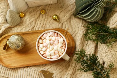 Noel yatağı. Tahta tepside marşmelovlu bir fincan sıcak çikolata, altın Noel süsleri, rahat örülmüş süveter ve köknar dalları. Kış higge duvar kağıdı