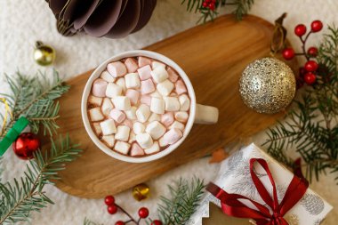 Noel yatağı. Bir fincan sıcak çikolata, marşmelov, noel süsleri ve hediye, rahat örülmüş süveter ve köknar dalları. Mutlu noeller. Kış kızlık zarı