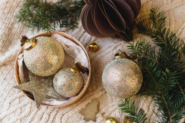 Noel yatağı. Noel altın mücevherleri, köknar dallarıyla örülmüş battaniye kutusunda. Kış tatili hazırlama estetiği. Mutlu Noeller.