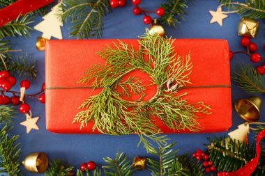 Mutlu Noeller! Sedir çelengi, yeşil köknar dalları, kırmızı böğürtlen ve mavi arka planda altın süslemeleri olan şık bir Noel hediyesi. Xmas geçmişi. Mutlu Noeller.