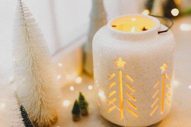 Mutlu Noeller! Pırıl pırıl parlayan Noel feneri ve camında altın ışıklarla süslenmiş kış ağacı süslemeleri. Atmosferik büyülü sahne. Noel tatili afişi. Metin için boşluk