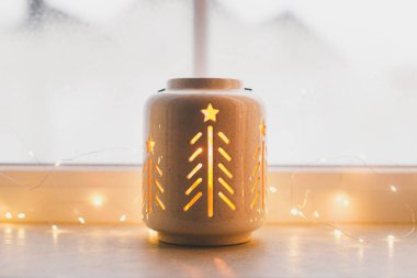 Mutlu Noeller! Vitrinde altın ışıklarla parıldayan şık bir yılbaşı feneri. Atmosferik büyülü sahne. Noel tatili afişi. Metin için boşluk