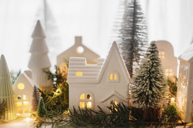 Mutlu Noeller! Şık bir Noel minyatür tatil köyü. Akşamları evleri, ağaçları ve altın ışıklarıyla pencereleri tıkanır. Atmosferik büyülü sahne. Noel bayrağı.