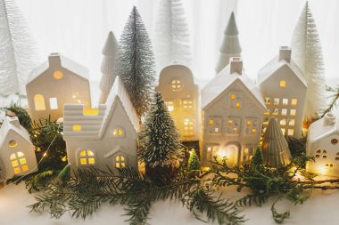 Noel sakin hayat, minyatür kış tatili köyü. Mutlu Noeller ve mutlu tatiller! Küçük beyaz seramik evler ve penceredeki karlı ağaçlar. Şenlikli stil dekorasyonu