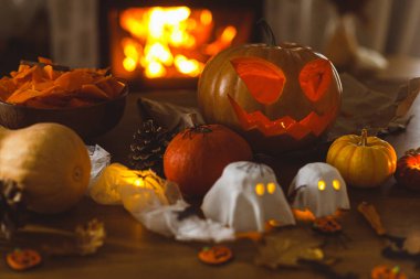 Balkabağı oyulmuş balkabağı, parlayan hayaletler ve akşamları masada örümcekler. Ürkütücü atmosferik cadılar bayramı dekorasyonları, yazı için yer. Mutlu Cadılar Bayramı!