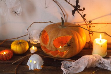 Cadılar Bayramı balkabağı, parlayan hayaletler, masada örümcekler ve yarasalar. Mutlu Cadılar Bayramı! Cadılar Bayramı dekoru, ürkütücü Jack o fener ve mumlarla dolu, mesaj için yer var. Şaka mı şeker mi?