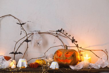 Mutlu Cadılar Bayramı! Korkunç balkabağı, parlayan hayaletler, masada örümcekler ve yarasalar. Cadılar Bayramı dekoru, ürkütücü Jack o fener ve mumlarla dolu, mesaj için yer var. Şaka mı şeker mi?