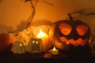 Korkunç Jack o fener kabağı, parlayan hayaletler, akşamları örümcekler ve yarasalar. Mutlu Cadılar Bayramı! Masada atmosferik cadılar bayramı dekorasyonu, metin için boşluk. Şaka mı şeker mi?