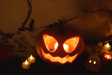 Ürkütücü Jack o fener kabağı, parlayan hayaletler, karanlıkta örümcekler ve yarasalar. Mutlu Cadılar Bayramı! Masada atmosferik cadılar bayramı dekorasyonu, metin için boşluk. Şaka mı şeker mi?