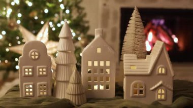 Mutlu Noeller! Noel ağacı ışıkları ve yanan şöminenin arka planında küçük evleri olan şık bir Noel tatil köyü. Atmosferik Noel arifesi. Tatil görüntüleri