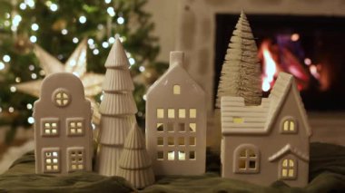Mutlu Noeller! Noel ağacı ışıkları ve yanan şöminenin arka planında küçük evleri olan şık bir Noel tatil köyü. Atmosferik Noel arifesi. Tatil görüntüleri