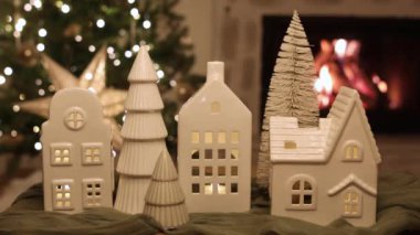 Noel ağacı ışıkları ve yanan şöminenin arka planında dekoratif evleri olan şık bir Noel tatil köyü. Atmosferik Noel arifesi. Tatil görüntüleri