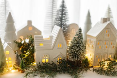 Noel 'de küçük seramik evler, beyaz karlı ağaçlar ve pencerelerde altın ışıklar. Mutlu Noeller! Atmosferik Noel sahnesi, minyatür tatil köyü. Xmas arkaplanı