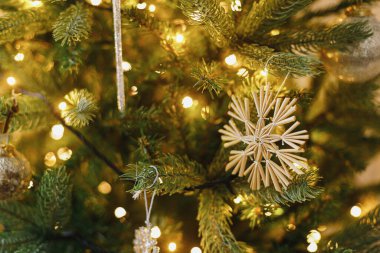 Samandan kar taneleri, klasik takılar ve altın ışıklarla süslenmiş güzel bir Noel ağacı. Kış tatili hazırlığı. Atmosfer sihirli arifesi. Ağacın üzerinde şık bir Noel süsü