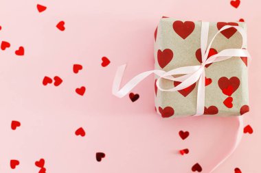 Sevgililer Günü yatıyordu. Kırmızı kalpli şık hediye kutusu ve pembe arka planda pembe fiyonk, kopyalama alanı. Sevgililer günün kutlu olsun. Aşk bayrağı