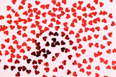 Kalpler düz yatıyordu. Sevgililer günün kutlu olsun. Pembe arka planda süslü kırmızı kalpler konfetisi. Aşk arkaplanı