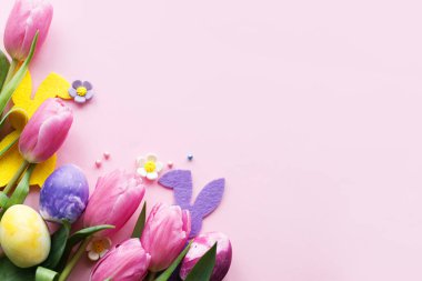 Paskalya düzlüğü. Tavşan kulaklı şık mermer paskalya yumurtaları ve pembe arka planda pembe laleler ve metin için yer. Paskalya modern afiş modeli. Mutlu Paskalyalar