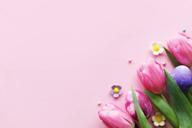 Paskalya düzlüğü. Paskalya yumurtaları ve pembe arka planda pembe laleler. Paskalya modern afiş modeli. Mutlu Paskalyalar