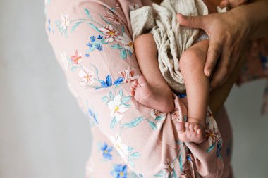Mutlu Anne kucağında küçük şirin bir bebek, küçük ayakları yakın. Anneler Günün kutlu olsun! Annelik ve ebeveynlik. Evlat edinme ve doğurganlık kavramı
