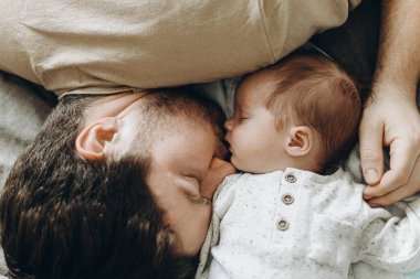 Babalar Günün kutlu olsun! Baba, küçük oğluyla yatıyor. Yakın plan, manzaralı. Babalık ve ebeveynlik. Çok güzel bir an. Evlat edinme ve doğurganlık kavramı
