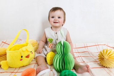 Paskalya bebeğinin paskalya sepetindeki renkli yumurta ve havuçlarla oynaması. Sevimli Paskalya tavşanı ve Paskalya avı konsepti. Mutlu Paskalyalar