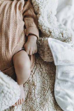 Küçük şirin bebek battaniyenin üzerinde uyurken bebek elini ve ayaklarını kapat. Küçük tatlı bebek yatakta uzan, mesaj için yer aç. Evlat edinme. Çocuk sağlığı ve cilt bakımı kavramı