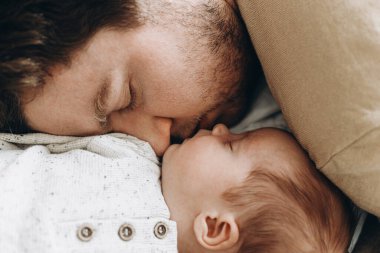 Babalar Günün kutlu olsun! Baba, küçük oğluyla yatıyor. Yakın plan, manzaralı. Babalık ve ebeveynlik. Çok güzel bir an. Evlat edinme ve doğurganlık kavramı
