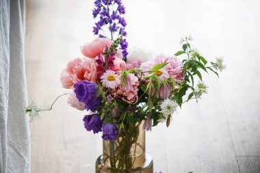 Çağdaş vazoda yaz çiçekleri olan güzel şakayıklar. Anneler Günün kutlu olsun. Evde çiçek aranjmanı.