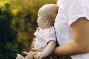 Anne, yaz otlağında yeni doğmuş bebeğe sarılıyor, annesinin kucağında küçük şirin bir bebeğe sarılıyor. Aşk, ilgi ve koruma konsepti. Anne ve oğlu. Anneler günün kutlu olsun.!