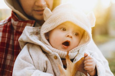 Sonbahar ormanlarında güz yaprağını babasının elinde tutan mutlu, sevimli bir oğlan. Babalık. Hoş çocuklu şık bir adam, rahat, sıcak kazaklar içinde sonbahar parkında sarılıyor.