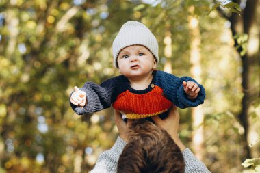 Babasının elinde komik duygular besleyen tatlı bir oğlan çocuğu sonbahar ormanlarında yakınlaşıyor. Babalık. Sevimli çocuğu olan şık bir adam sıcak kazaklar içinde sonbahar parkında eğleniyor ve dinleniyor.