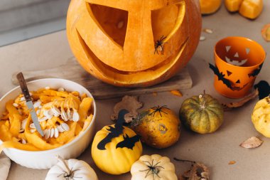 Mutlu Cadılar Bayramı. Cadılar bayramı için masaya balkabağı oyma, Cadılar Bayramı süsü, şaka mı şeker mi kovası, örümcekler ve yarasalar yaklaşır. Aile Jack O Feneri yapıyor, Tatil hazırlığı detayları