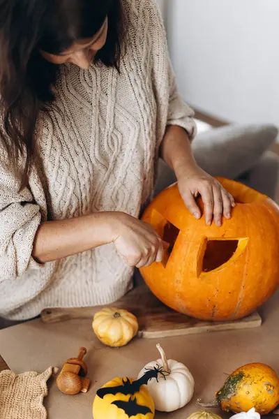 Mutlu Cadılar Bayramı. Cadılar bayramı balkabağını ürkütücü cadılar bayramı dekoruyla oyan mutlu bir kadın. Yaklaş. Aile Jack O feneri yapıyor, bayram zamanı