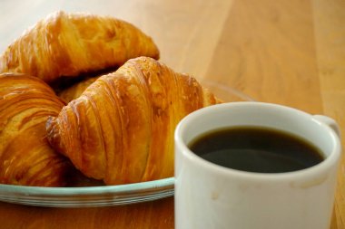 Kruvasan ve kahveli kahvaltı aperatifleri manzarayı kapatır.