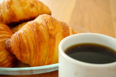 Kruvasan ve kahveli kahvaltı aperatifleri manzarayı kapatır.