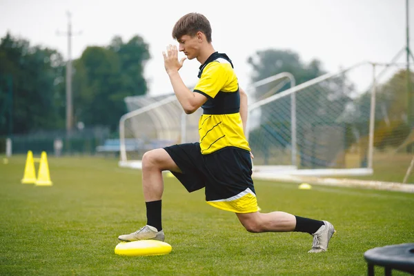 Footballer at Stretching and Balance Training Unit. Player Putting Foot on Balance Cushion at Training Field