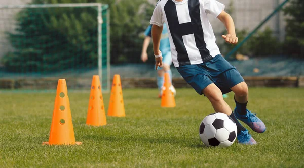 Boy Dribble a Soccer Ball Between Cones. Football Training Class For Kids. Children at Sports Summer Camp