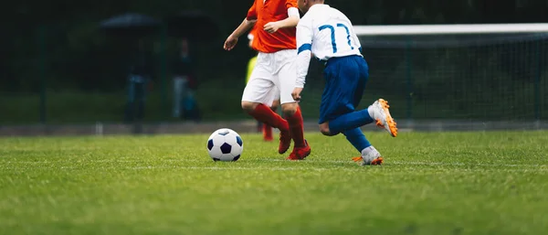 stock image Two boys kicking soccer ball. Young teenage boys playing sports together on grass field. Kids in sport uniforms compete for soccer ball