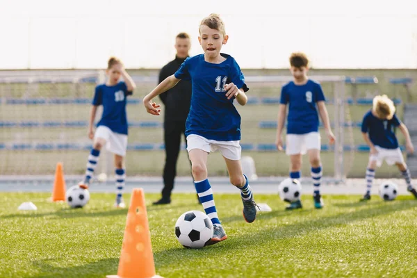 年轻的欧洲足球运动员在运球 快乐的孩子们训练足球操练 与学校青年教练一起训练的足球男孩 — 图库照片