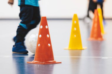 Futsal training drill for school children. Little boy kicking indoor soccer ball during practice training class