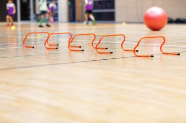 İç saha antrenman sahasında eğitim engelleri. Spor Salonunda Spor Eğitiminde Okul Çocukları. Gençler için Beden Eğitimi Eğitim Ekipmanı. Bulanık Arkaplanda Gençlik Eğitimi
